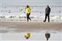 personer går ved strand