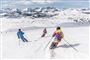 tre personer står på ski