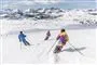 tre personer står på ski
