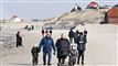 mennesker i vintertøj på en strand