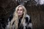 Sanne Salomonsen portræt ude i naturen ved nogle siv.