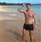 en mand i badeshorts på en strand