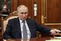 Vladimir Putin sidder i en stol og ser sur ud