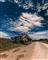 En tank under en skyet men solrig himmel