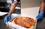 Mand lægger pizza i bakke