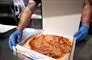 Mand lægger pizza i bakke