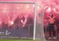 En gruppe maskerede fans indhyllet i romerlys og røg