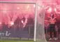 En gruppe maskerede fans indhyllet i romerlys og røg