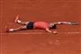 tennisspiller ligger på banen efter sejr