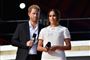 harry og meghan står på scene med mikrofoner 