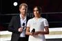 harry og meghan står på scene med mikrofoner 