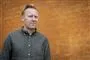 Anders Breinholt ser sammenbidt ud op ad en orange mur