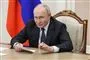 Vladimir Putin sidder i en stol og ser sur ud