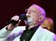 Roger Whittaker synger i en mikrofon i hvid blazerjakke.
