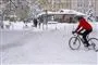 En mand cykler i sne