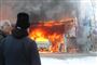 Folk står og kigger på en brandende garage