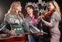 tre kvinder i musikband poserer 