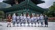 11 personer poserer foran tempel