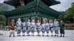 11 personer poserer foran tempel