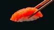 et stykke sushi taget med pinde