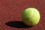 Tennisbold på en grusbane