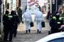 Retsmedicinere går ind i et område i Berlin under en politiaktion.