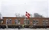 en flagstang med flaget på halv ved en skole