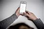 person sidder med mobiltelefon 