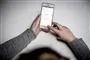 person sidder med mobiltelefon 
