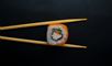 et stykke sushi mellem to spisepinde