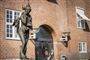 statue foran rød bygning