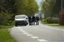 En hvid kassevogn og flere folk omkring