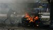 En afghansk betjent forsøger at slukke ilden efter en selvmordsbombe i Kabul. Foto: AP/Rafiq Maqboo / POLFOTO
