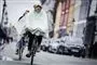 person cykler i regnen