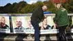 to personer hænger plakater op
