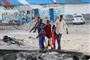 Folk bærer liget af en kvinde væk efter et blodigt angreb sendt fredag på civile på en populær strand i Somalias hovedstad, Mogadishu.

