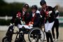 tre glade piger med medaljer og ridehjelme