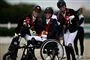 tre glade piger med medaljer og ridehjelme