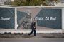 En mand går forbi en mur i byen Kursk, hvor et banner hylder de russiske soldater, der kæmper i Ukraine. Det er denne region, hvor der nu - ifølge den ukrainske militære efterretningstjeneste - er indsat nordkoreanske soldater.