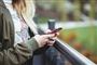 person står med mobiltelefon