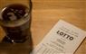 lottokupon og et glas kaffe på bord