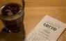 lottokupon og et glas kaffe på bord