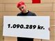 mand står med skilt med påskriften 1.090.289. kr. 
