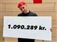 mand står med skilt med påskriften 1.090.289. kr. 