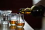 der skænkes whisky i glas