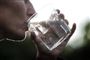 en person drikker vand af et glas