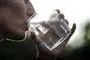 en person drikker vand af et glas