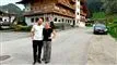 to glade personer foran et hotel
