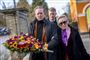 tre mennesker med blomster ved en kirke