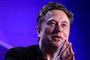 Elon Musks smilende ansigt med hænderne samlet foran haven